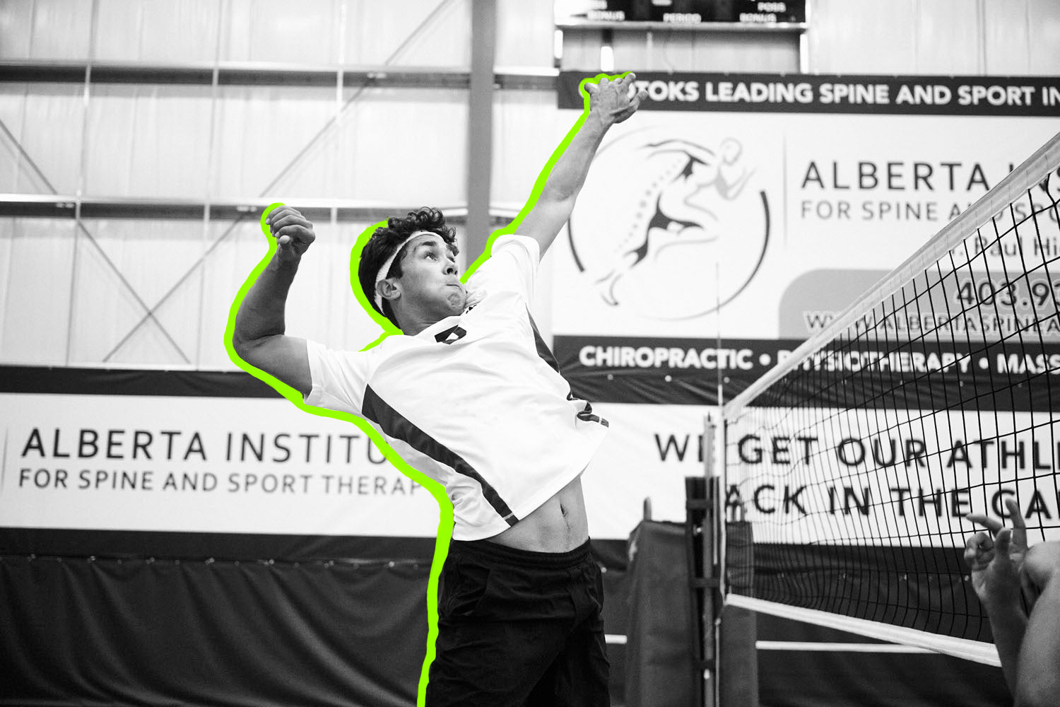 male athlete jumping to hit volleyball over net